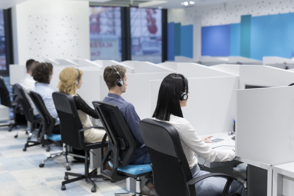 Referência de call center com atendentes e cadeiras corporativas